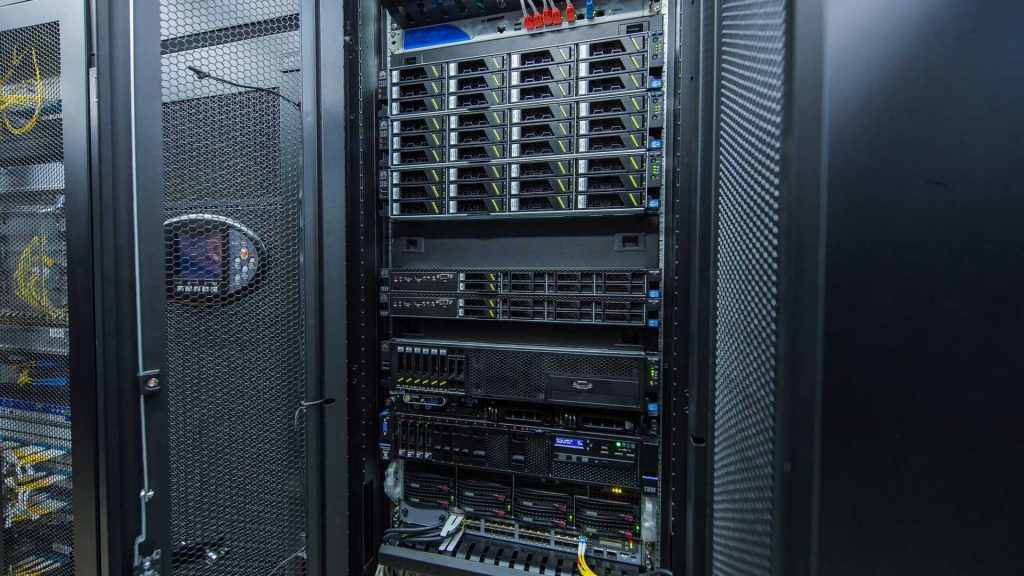 Serwerownia w Poznaniu z metalowymi szafami rack i niebieskimi diodami LED, infrastruktura dla elektrośmieci i recyklingu sprzętu elektronicznego.